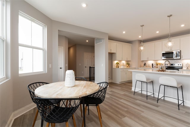 dining room featuring baseboards, visible vents, light wood-style floors, and recessed lighting