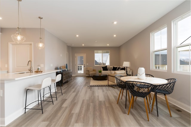 dining space featuring plenty of natural light, baseboards, light wood finished floors, and recessed lighting