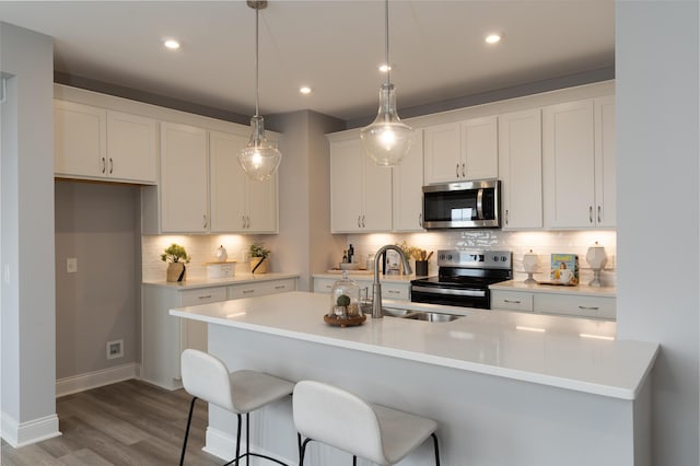 kitchen featuring white cabinetry, tasteful backsplash, light countertops, and stainless steel appliances