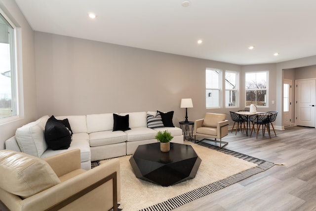 living room featuring baseboards, light wood-type flooring, and recessed lighting