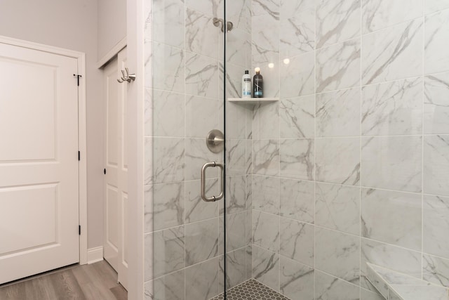 bathroom with a shower stall and wood finished floors