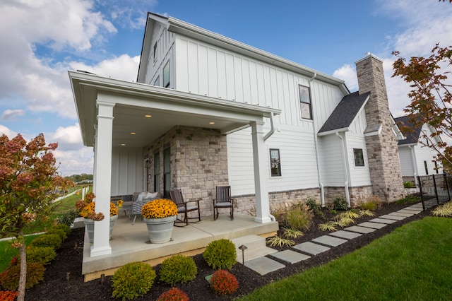 rear view of property featuring covered porch