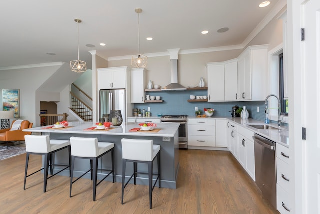 kitchen featuring wood-type flooring, backsplash, wall chimney exhaust hood, and stainless steel appliances