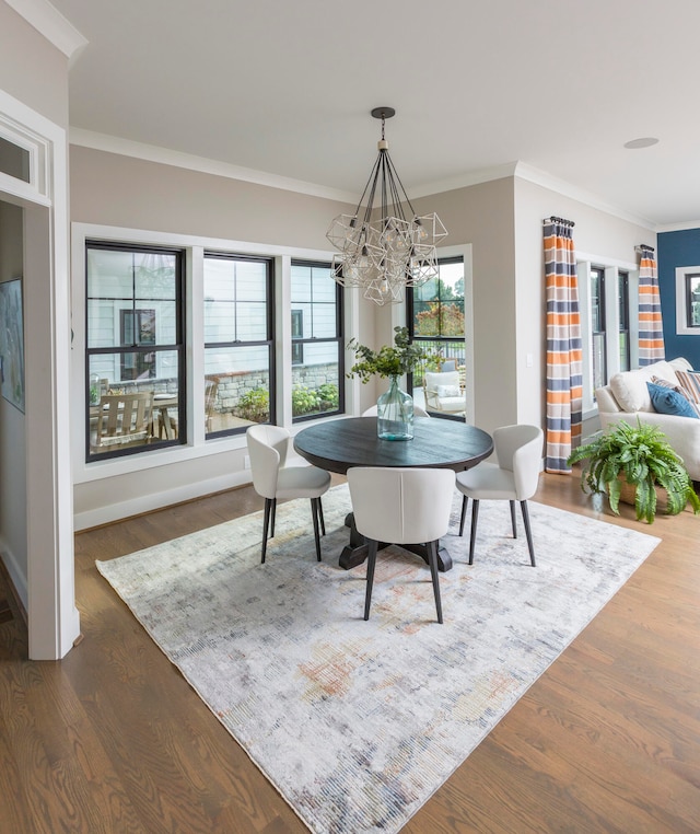 dining space featuring an inviting chandelier, dark hardwood / wood-style flooring, and ornamental molding