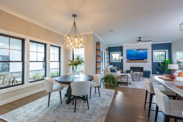 dining space featuring a healthy amount of sunlight, a large fireplace, and dark hardwood / wood-style flooring