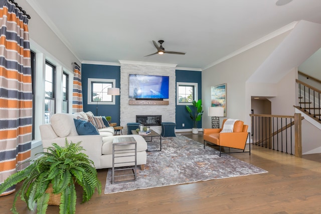 living room with plenty of natural light, ceiling fan, a fireplace, and hardwood / wood-style flooring