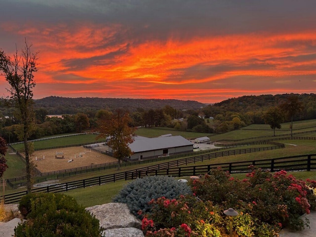 yard at dusk featuring a rural view