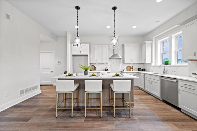 kitchen featuring stainless steel dishwasher, a center island, white cabinetry, and tasteful backsplash