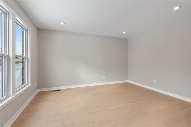 spare room featuring light hardwood / wood-style floors and a wealth of natural light