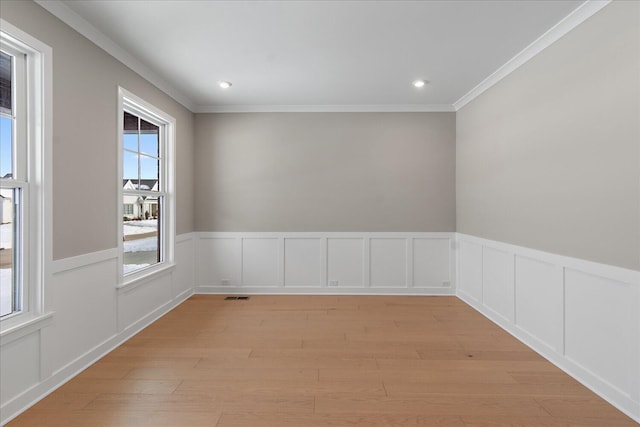 unfurnished room featuring light hardwood / wood-style floors and crown molding