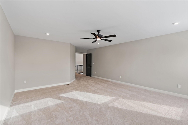 empty room with ceiling fan and light colored carpet