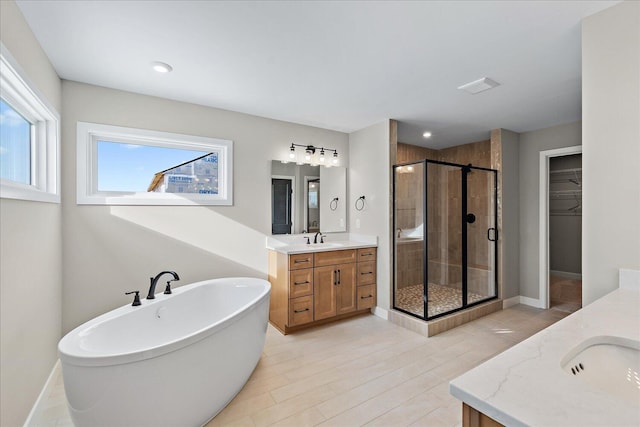 bathroom featuring vanity, plenty of natural light, and shower with separate bathtub