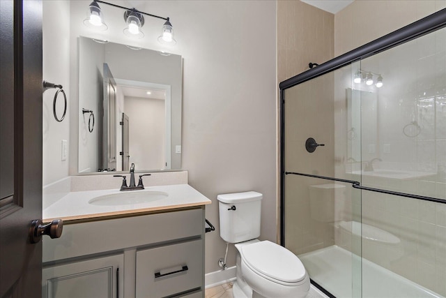 bathroom with an enclosed shower, vanity, and toilet