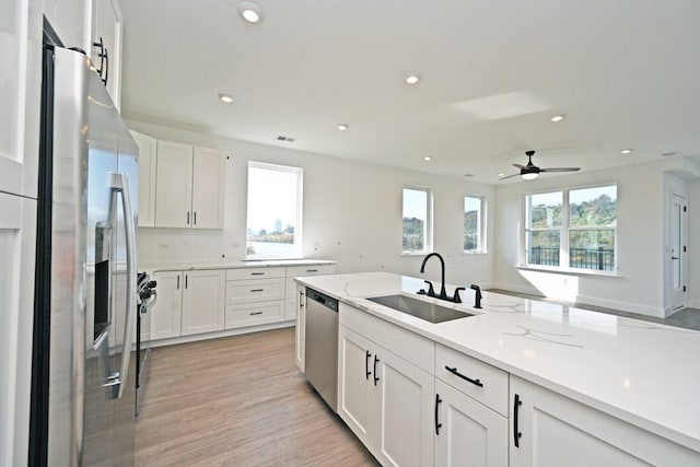 kitchen featuring white cabinetry, appliances with stainless steel finishes, sink, and a healthy amount of sunlight