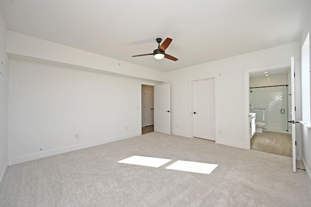 unfurnished bedroom featuring ensuite bathroom and light carpet