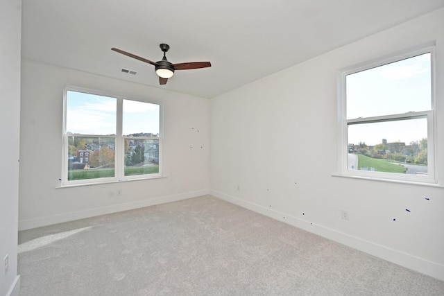 carpeted spare room featuring ceiling fan