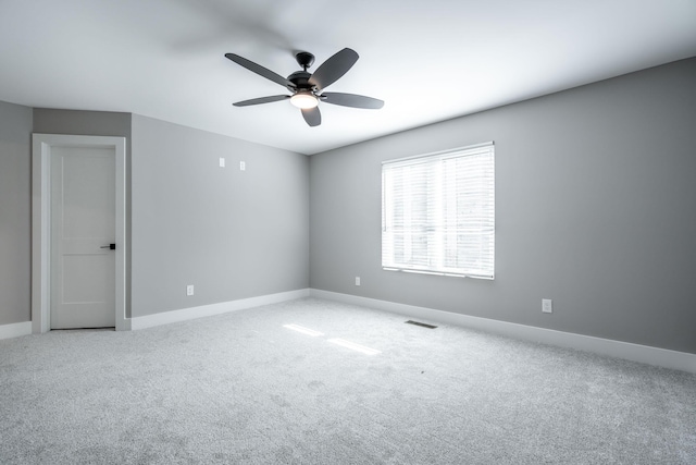 carpeted spare room with ceiling fan