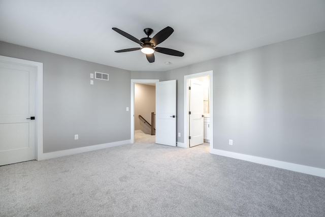 unfurnished bedroom featuring ceiling fan, light carpet, and ensuite bath