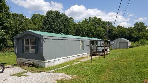 view of side of home with an outbuilding and a yard