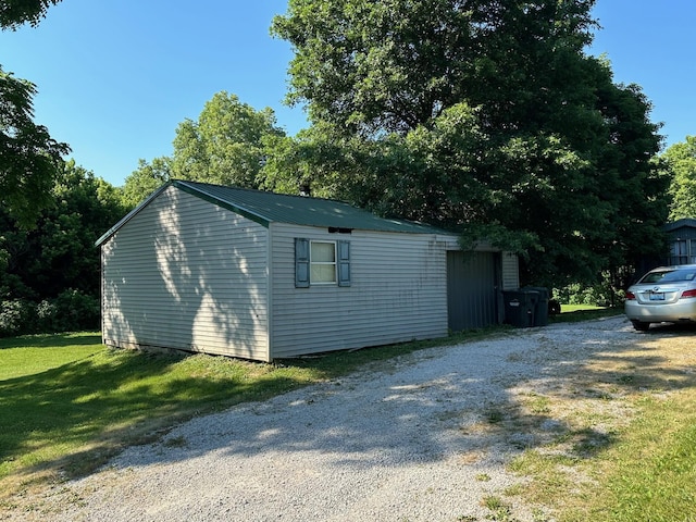 view of side of home featuring an outbuilding and a lawn