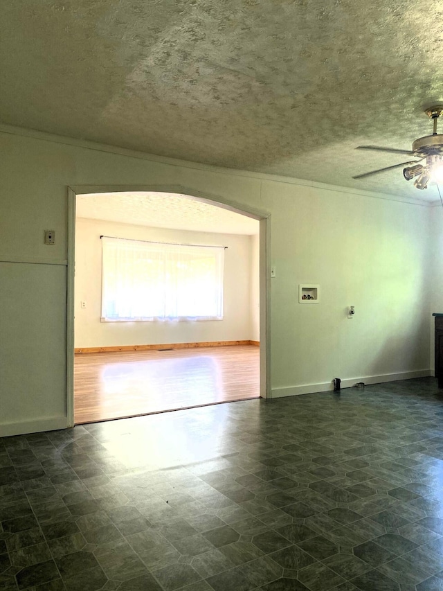 unfurnished room featuring a textured ceiling, ceiling fan, and ornamental molding