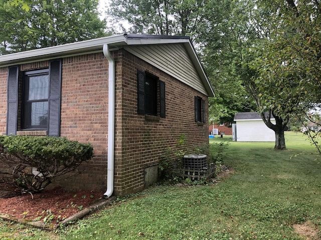 view of home's exterior with brick siding, a yard, and central air condition unit