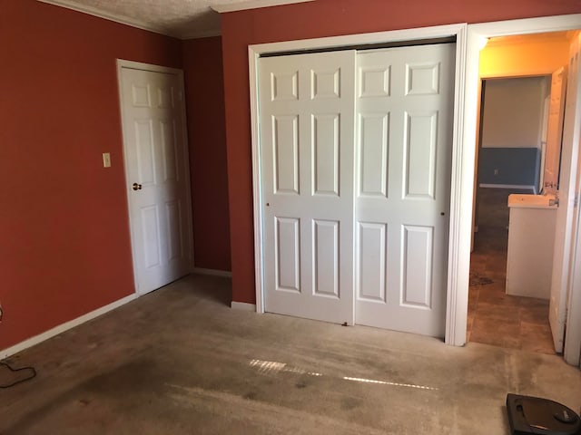 unfurnished bedroom with a closet, carpet floors, and a textured ceiling