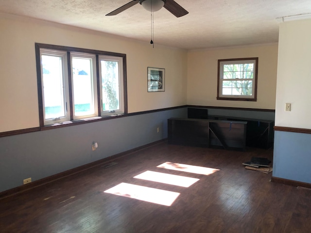 spare room with visible vents, ceiling fan, a textured ceiling, wood finished floors, and baseboards