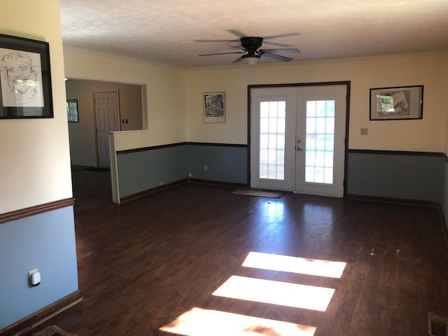 empty room with a textured ceiling, ornamental molding, wood finished floors, and french doors