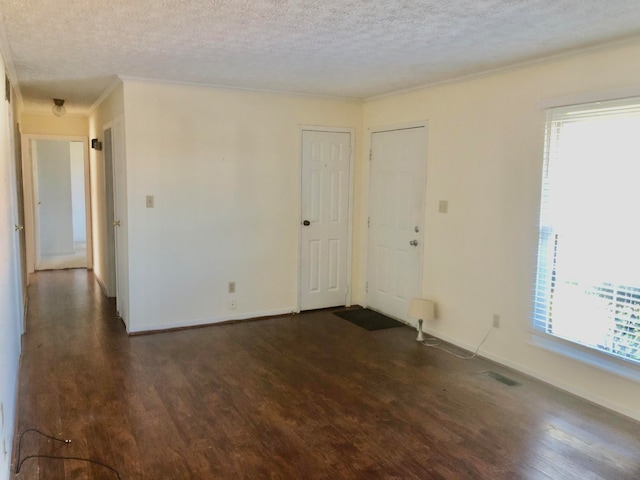 unfurnished room featuring crown molding, dark hardwood / wood-style floors, and a textured ceiling