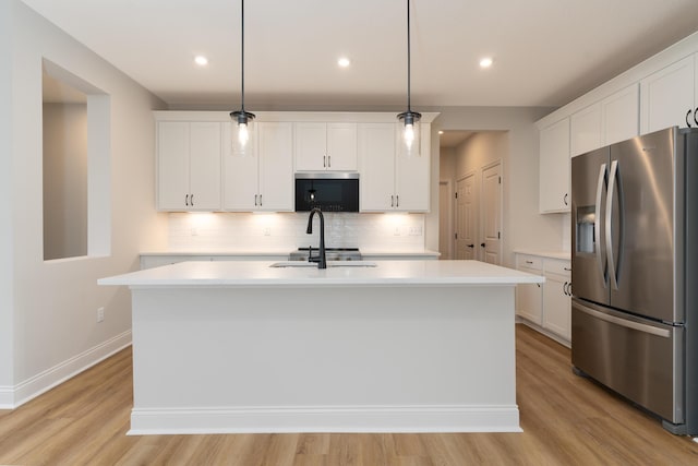 kitchen with pendant lighting, white cabinetry, a kitchen island with sink, and stainless steel appliances