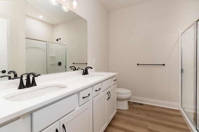 bathroom featuring vanity, hardwood / wood-style floors, toilet, and walk in shower