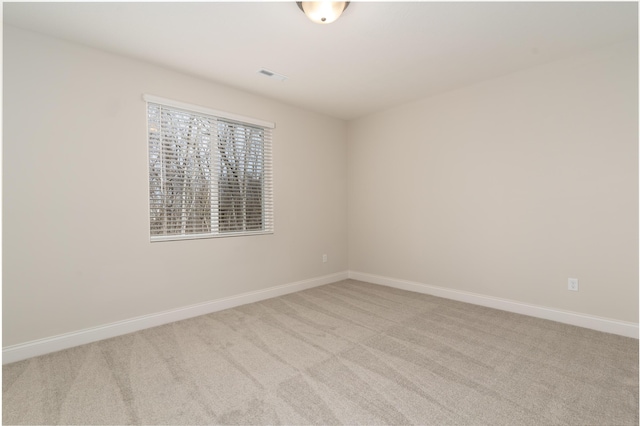 unfurnished room featuring light carpet