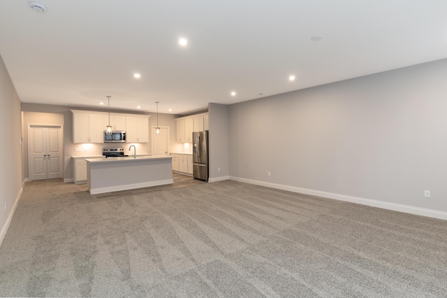 unfurnished living room with sink and light colored carpet