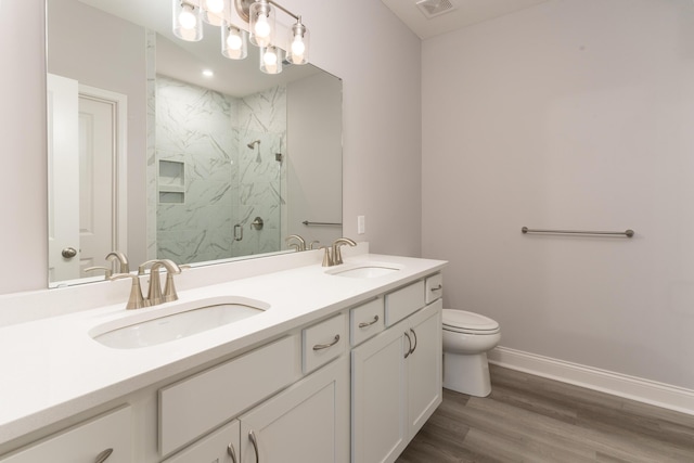 bathroom featuring wood-type flooring, vanity, an enclosed shower, and toilet