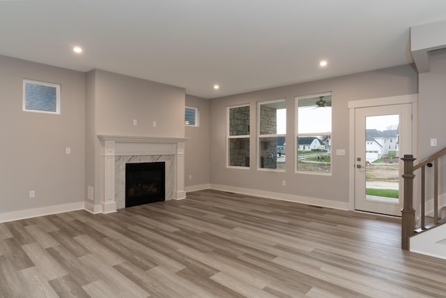 unfurnished living room with a premium fireplace and light hardwood / wood-style flooring