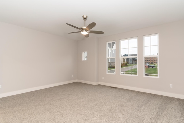 carpeted spare room with ceiling fan