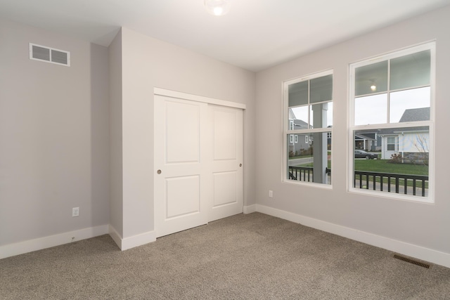 unfurnished bedroom featuring carpet and a closet