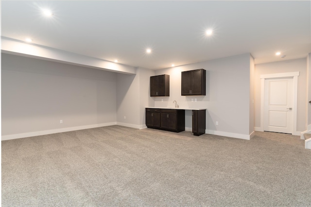 basement with sink and light colored carpet