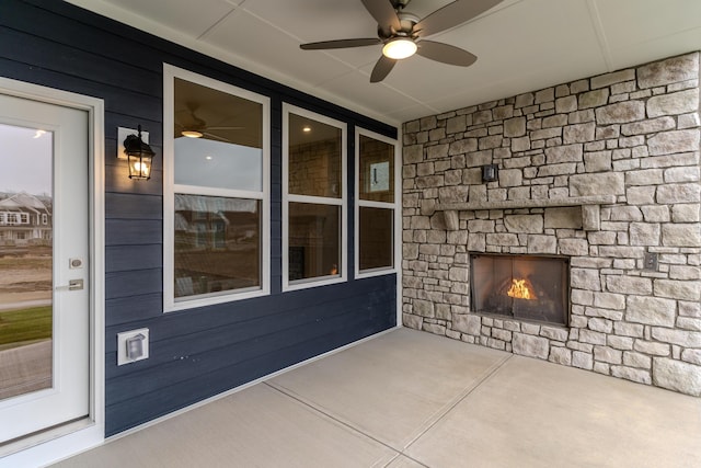 view of patio featuring an outdoor stone fireplace and ceiling fan