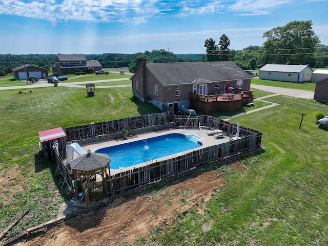 view of pool with a gazebo, a wooden deck, and a lawn