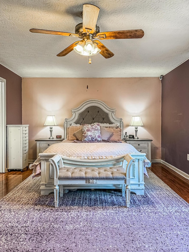 bedroom with ceiling fan, wood-type flooring, and a textured ceiling