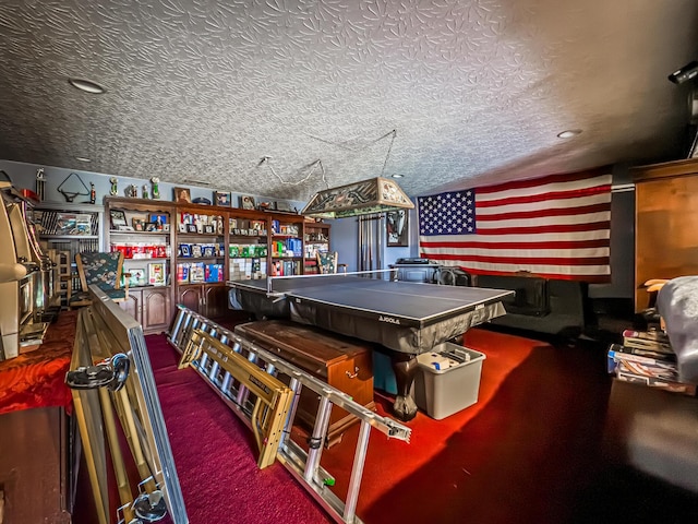 game room featuring dark colored carpet and a textured ceiling