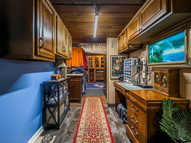 kitchen featuring dark wood-type flooring, built in desk, and wood ceiling