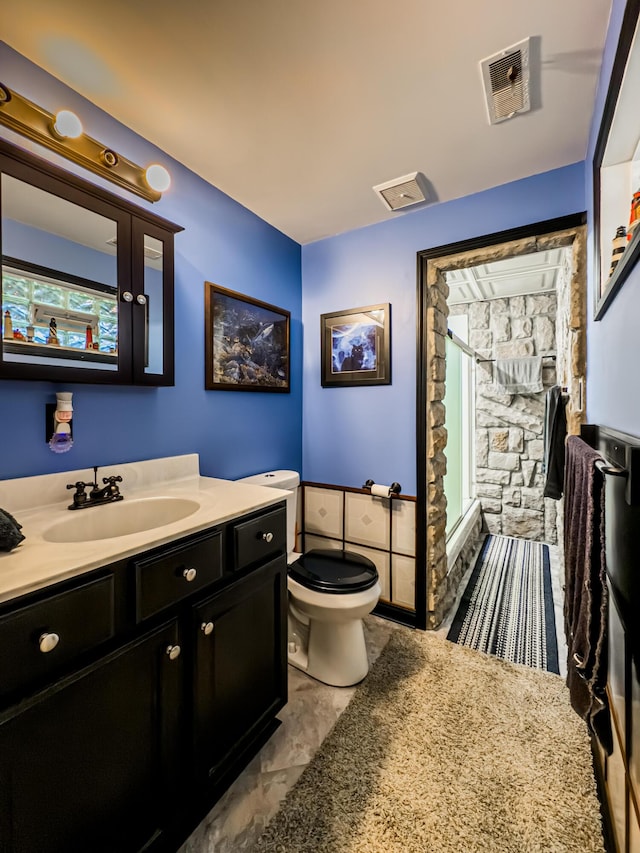 bathroom with walk in shower, vanity, and toilet