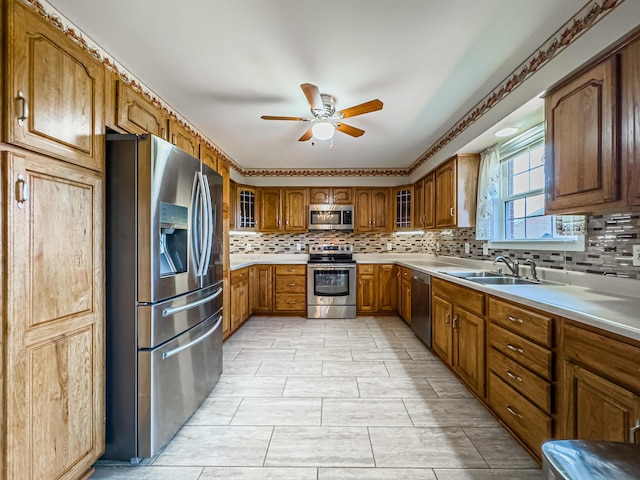 kitchen featuring sink, decorative backsplash, ceiling fan, and appliances with stainless steel finishes