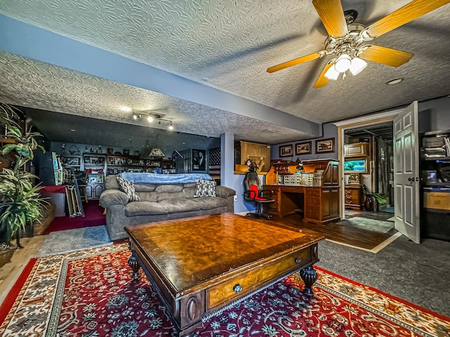 living room featuring ceiling fan and a textured ceiling