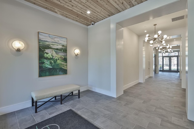 hall with ornamental molding, wood ceiling, french doors, and an inviting chandelier