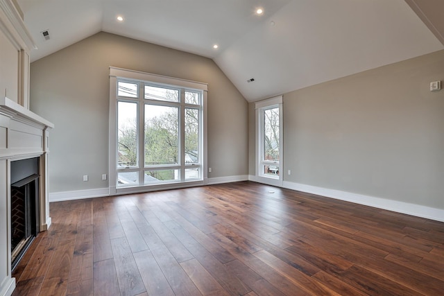 unfurnished living room featuring vaulted ceiling and dark wood-type flooring