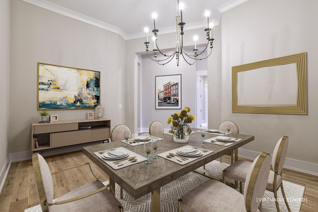 dining space with hardwood / wood-style floors, crown molding, and a chandelier